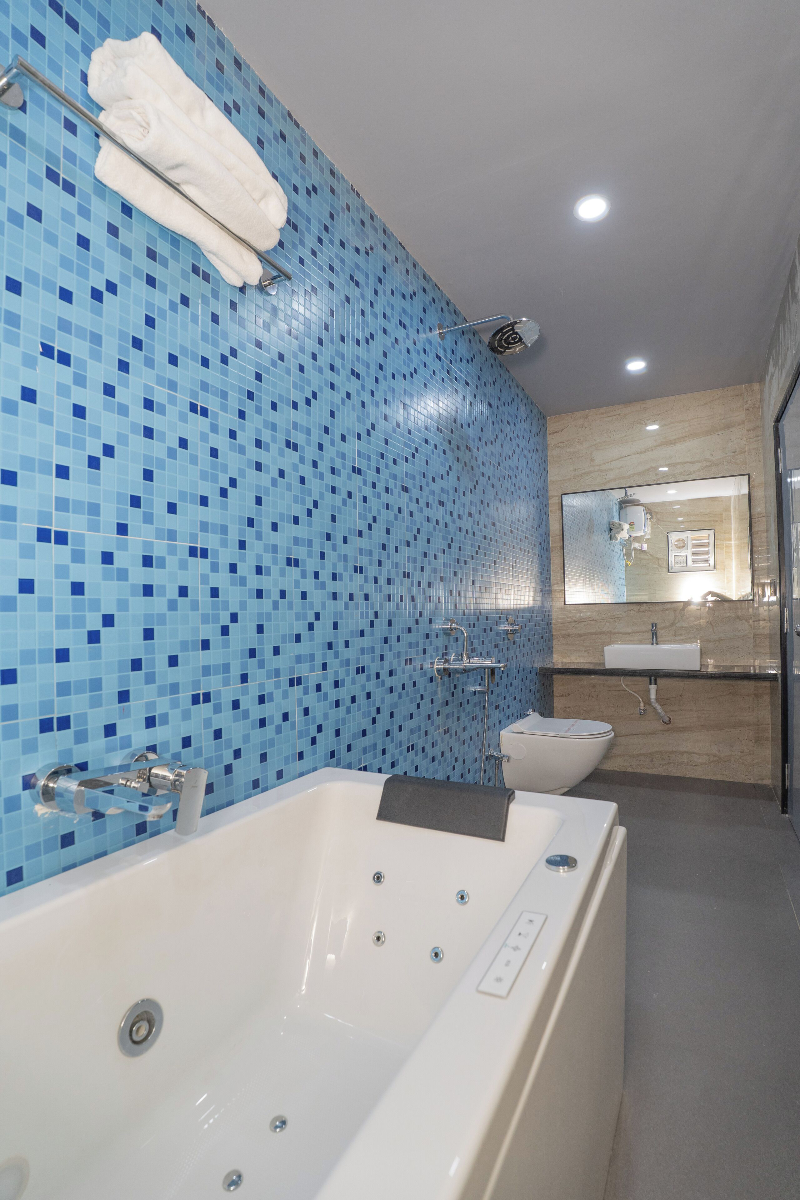 A modern bathroom with a large bathtub, a sink, and a toilet.