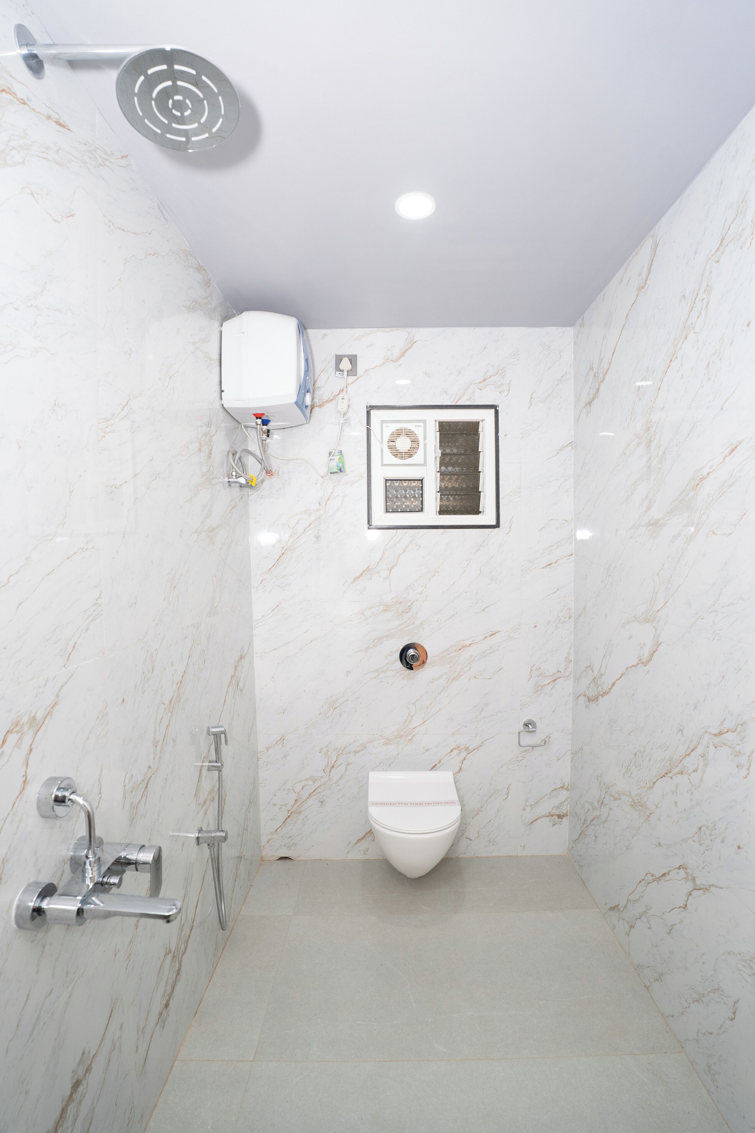 A bathroom with a shower, toilet, and a wall-mounted air purifier.