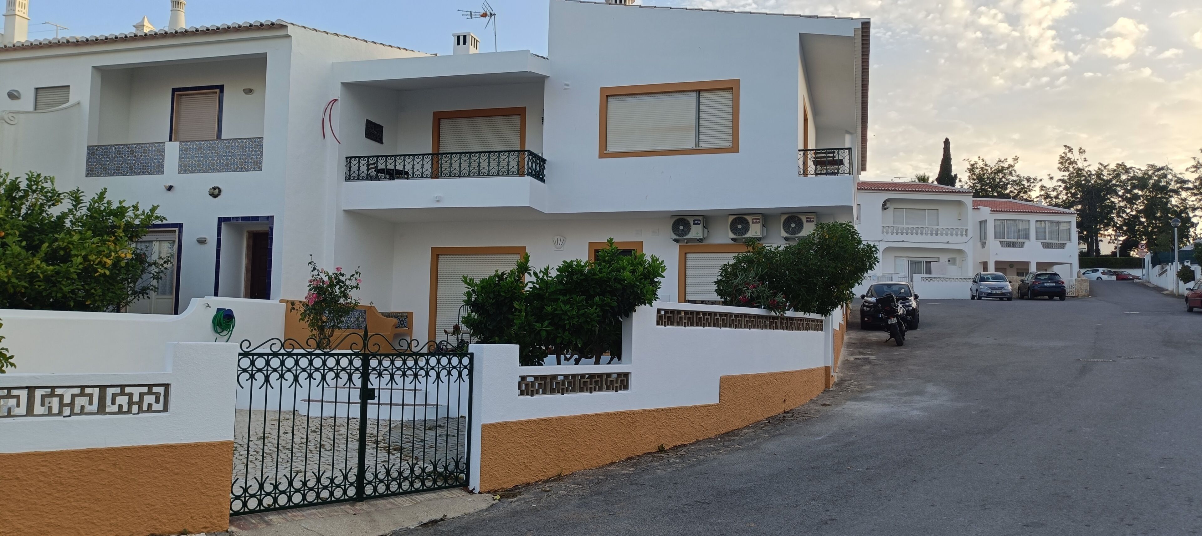 A multi-story residential building with balconies, air conditioning units, and a gated entrance.