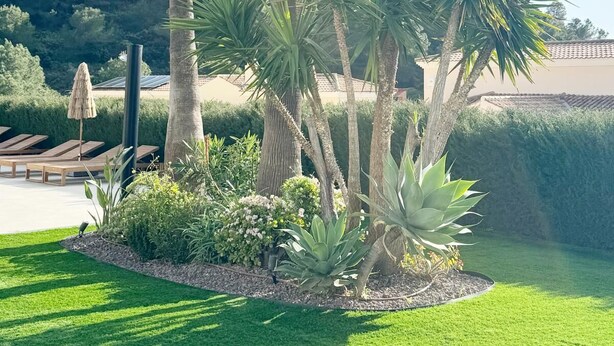 A well-maintained garden with palm trees, a grassy lawn, and a pool area with lounge chairs. - Elegant Private Villa with Pool & Scenic View (Mijas)