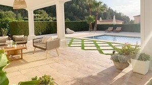 A covered outdoor area with a pool, seating, and potted plants. - Elegant Private Villa with Pool & Scenic View (Mijas)