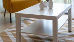 A modern living room with a white table, a mustard-colored sofa, and three white vases. - LIV - Comfortable Athens Studio S8-2c (Athens)