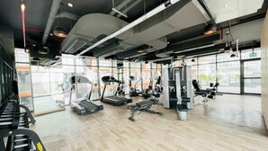 Una palestra con tapis roulant, macchinari per pesi e panche.