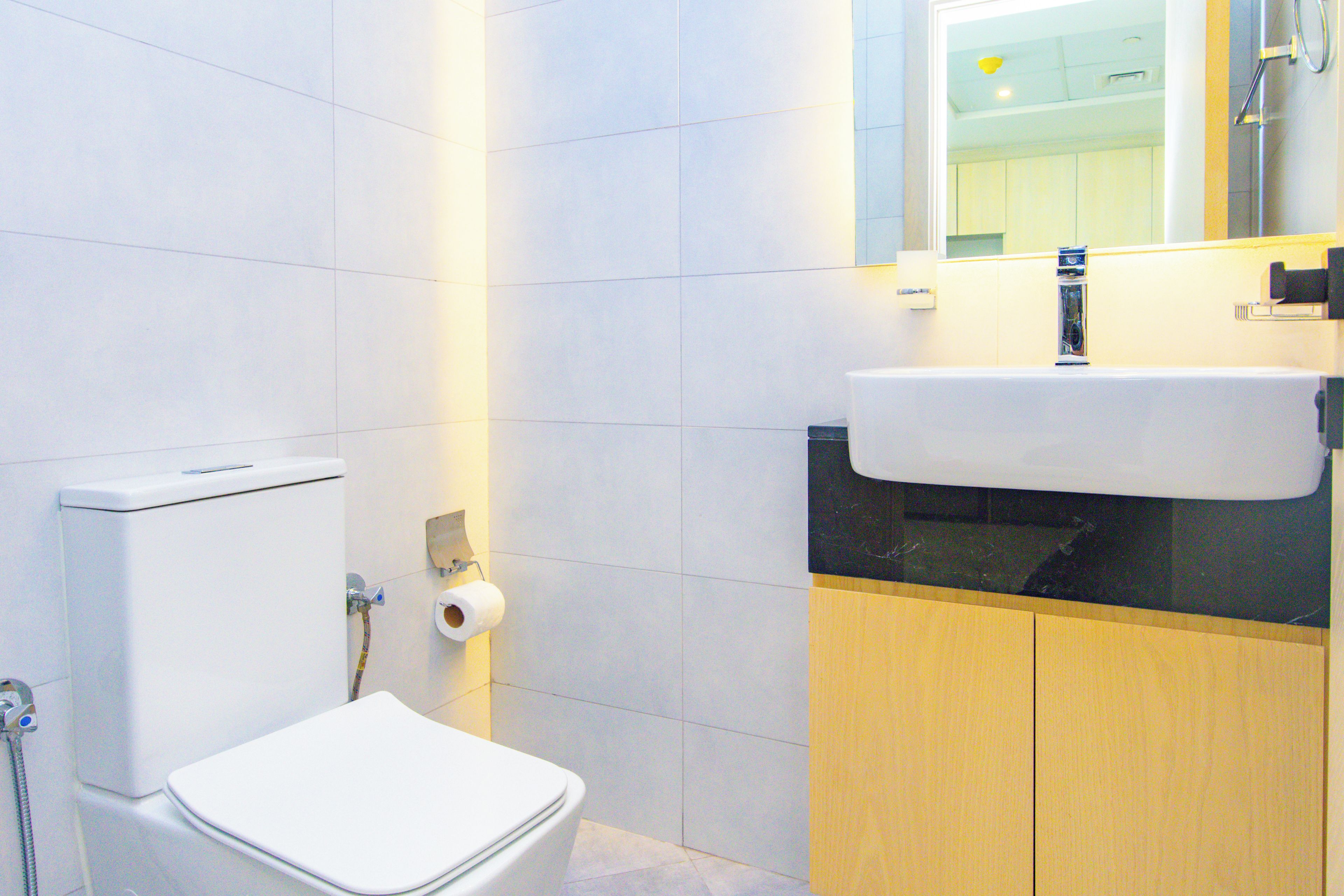 Une salle de bain avec des toilettes, un lavabo et un miroir.