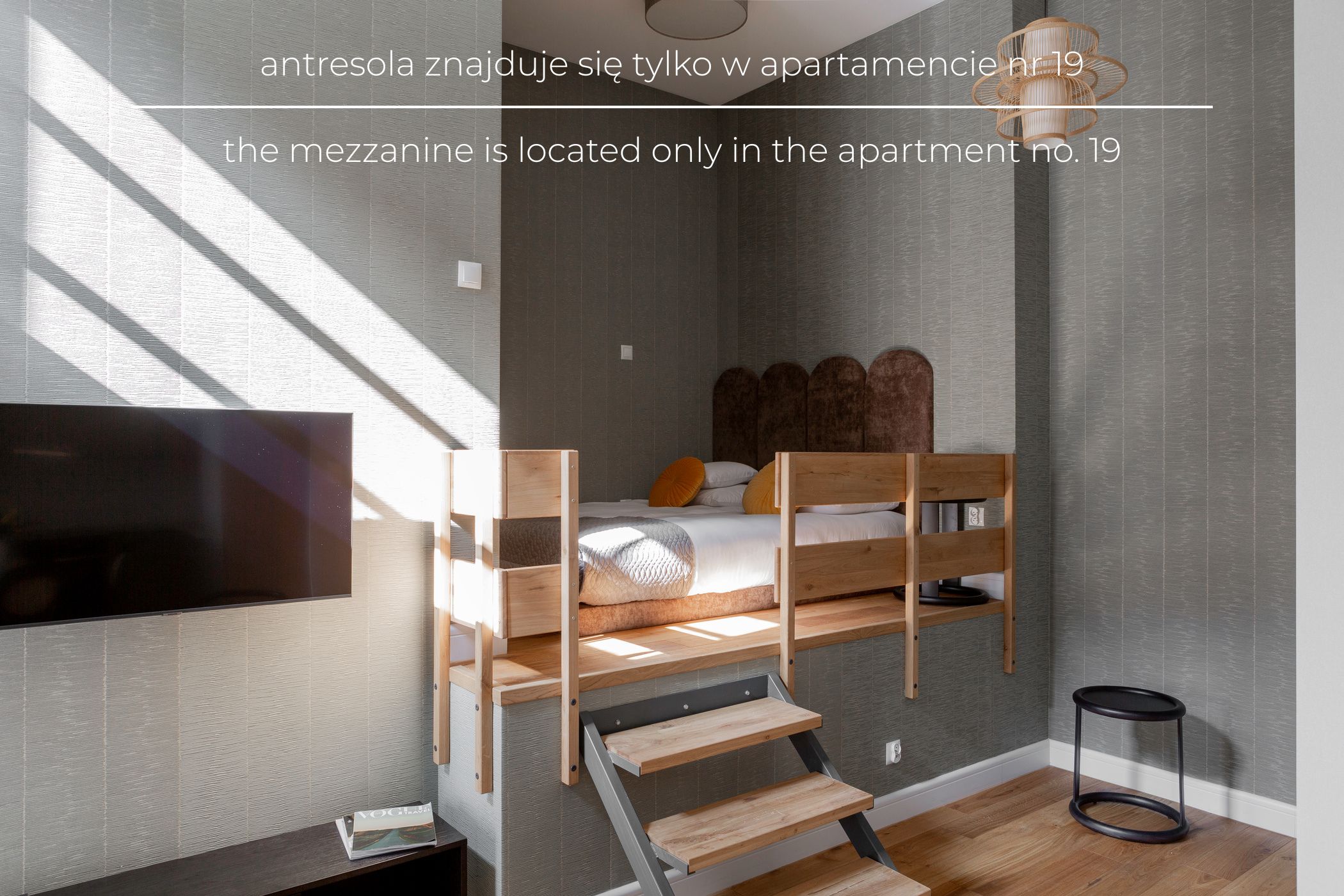 A bedroom with a bunk bed, a TV mounted on the wall, and a small table with a magazine.