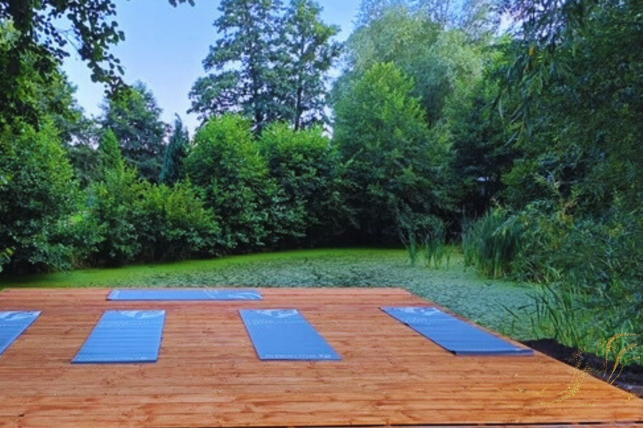 Eine Holzterrasse mit blau ausliegenden Yogamatten für Yoga im Freien.