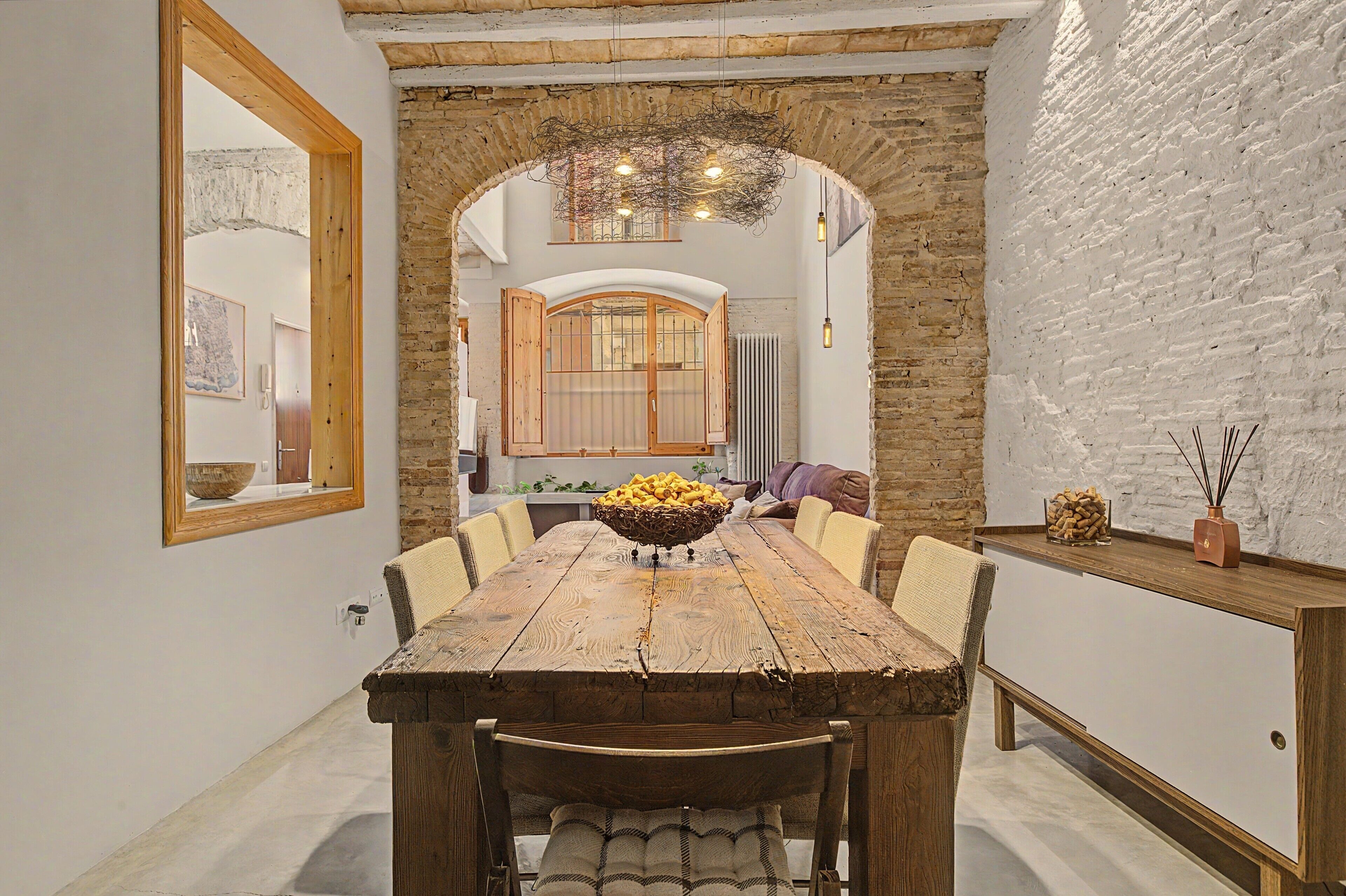 Une salle à manger rustique avec une table en bois, des chaises et un élément décoratif central.