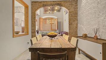 Une salle à manger rustique avec une table en bois, des chaises et un élément décoratif central.