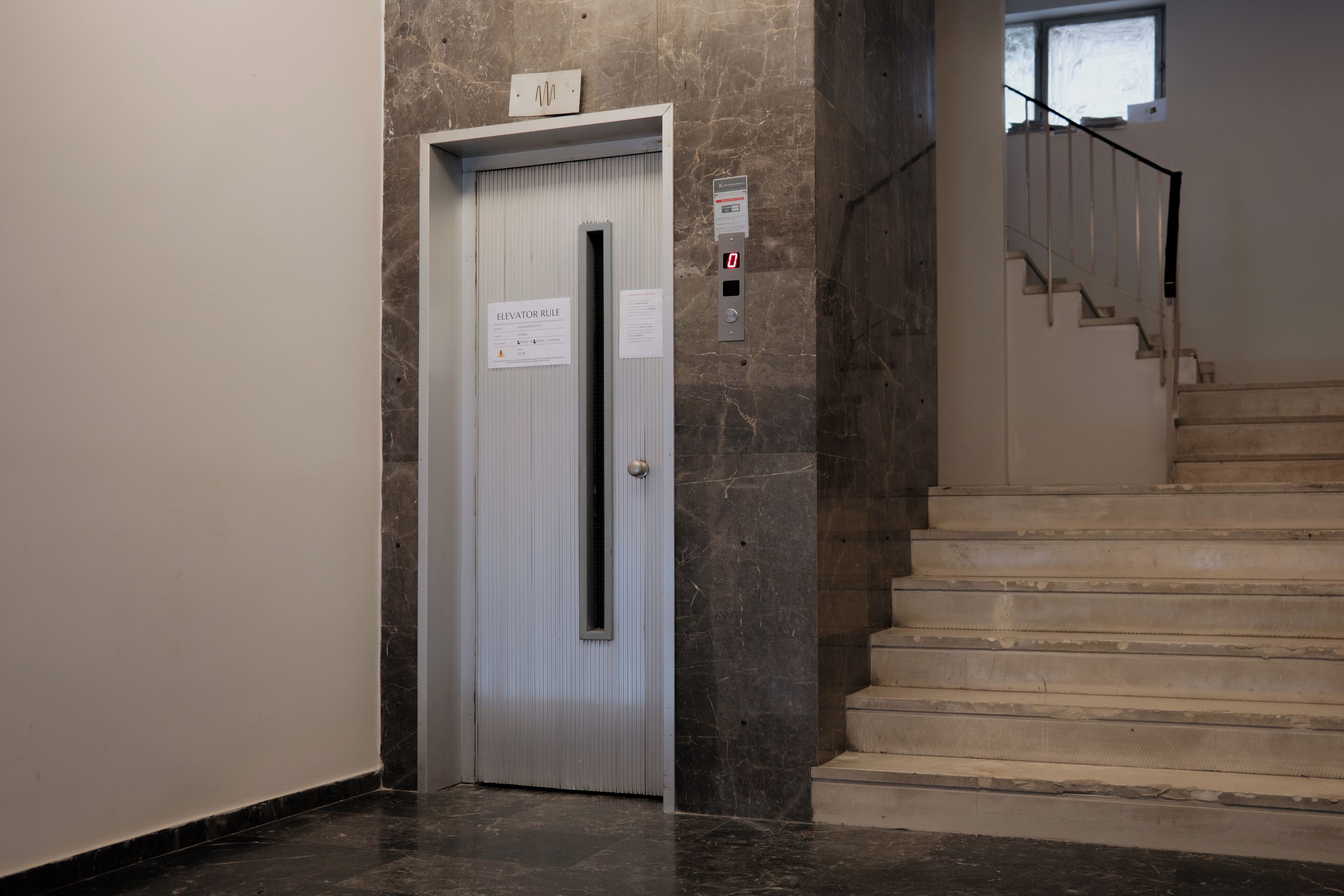 Un ascenseur doté d’un panneau de commande et d’une affiche indiquant les règles d’utilisation de l’ascenseur.