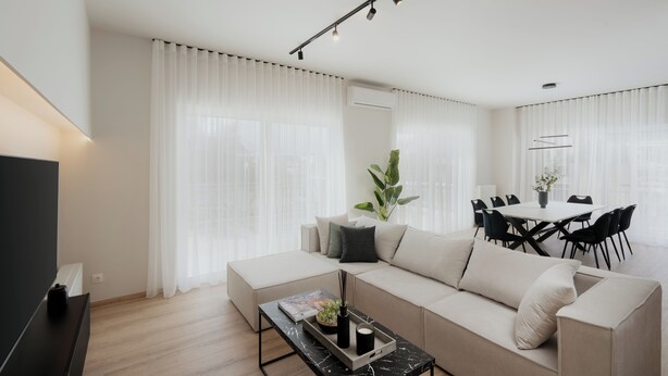 A modern living room with a sofa, coffee table, and dining area. - Luxury & Spacious Penthouse in Athens with Terrace  (Athens)