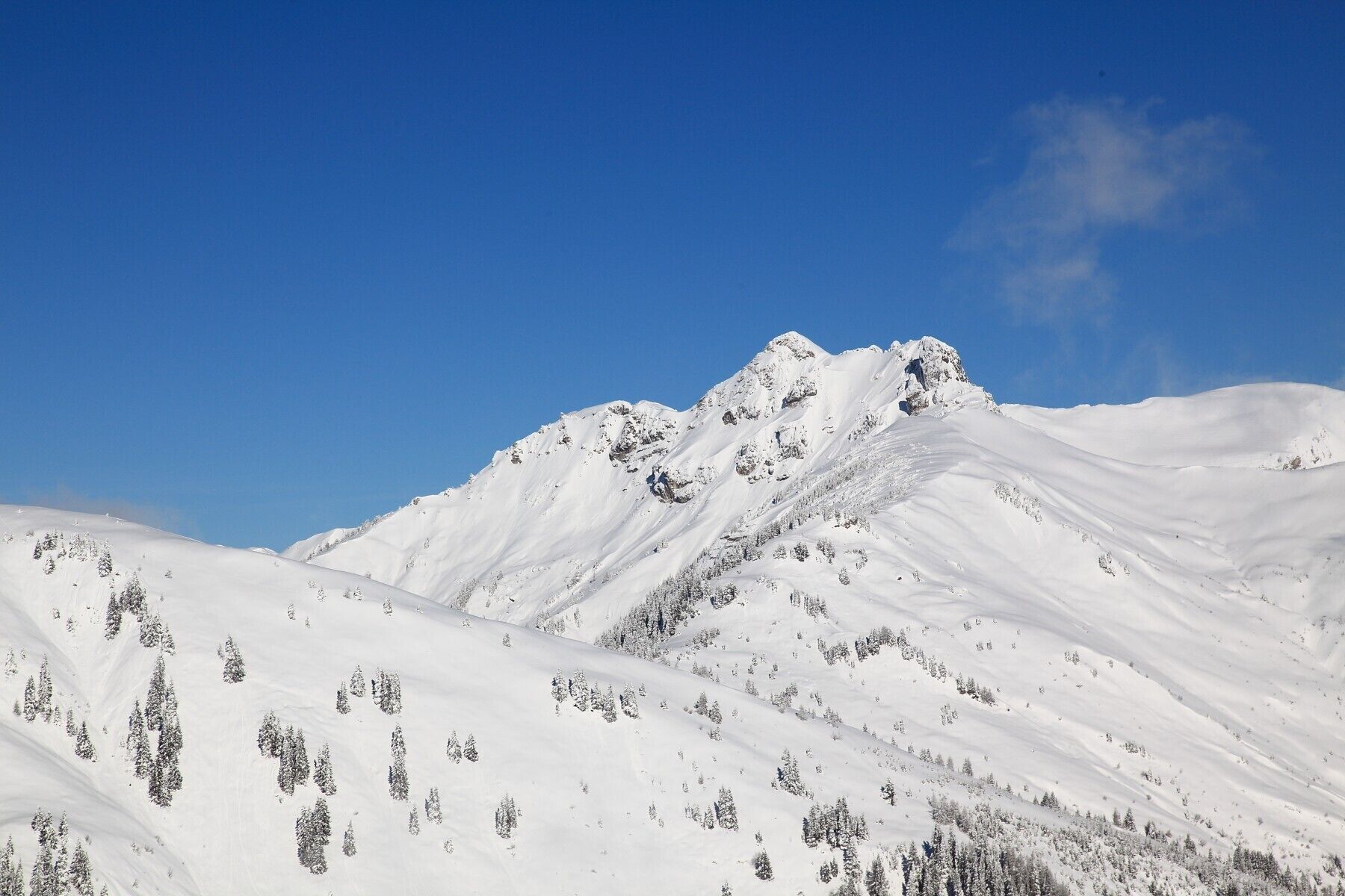 A snow-covered mountain with a clear blue sky.