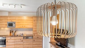 A modern kitchen with wooden cabinets, a microwave, and a hanging light fixture. - Apartment 'Stockinger B4' with Mountain View, Shared Garden and Wi-Fi (Unterberg)
