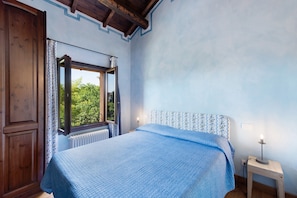 A bedroom with a bed, a window, a radiator, and a bedside table with a lamp. - Cascine di Villa Schella with Pool – Relaxing Oasis for Groups and Families (Ovada)