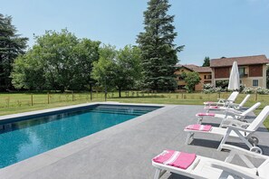 A swimming pool with lounge chairs and a building in the background. - Cascine di Villa Schella with Pool – Relaxing Oasis for Groups and Families (Ovada)