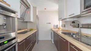 Een moderne keuken met roestvrijstalen apparatuur, een vaatwasser en een dubbele spoelbak.