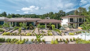 Un complexe hôtelier comprenant plusieurs bâtiments, un jardin aménagé et un espace piscine.