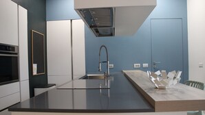 Una cucina moderna con isola centrale, lavello in acciaio inossidabile e forno integrato.