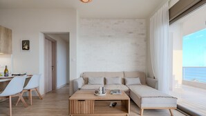 Una sala de estar moderna con un sofá, una mesa de centro y un comedor con sillas.
