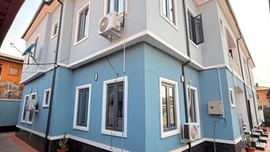 Un bâtiment à deux étages, doté d’un toit plat, de nombreuses fenêtres et de câbles électriques apparents à l’extérieur.