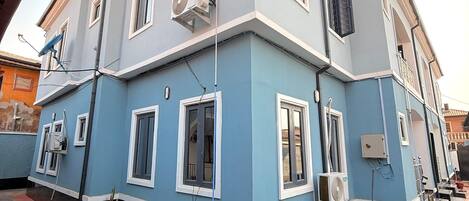 Un bâtiment à deux étages, doté d’un toit plat, de nombreuses fenêtres et de câbles électriques apparents à l’extérieur.