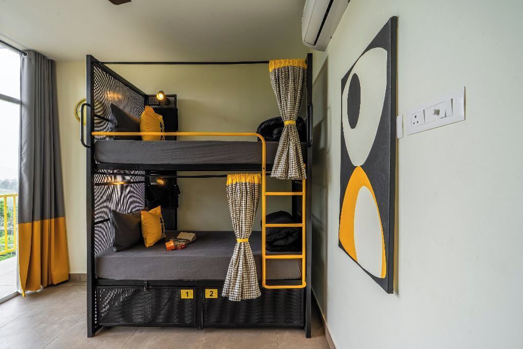 A bunk bed room with a ladder, curtains, and a wall-mounted artwork.