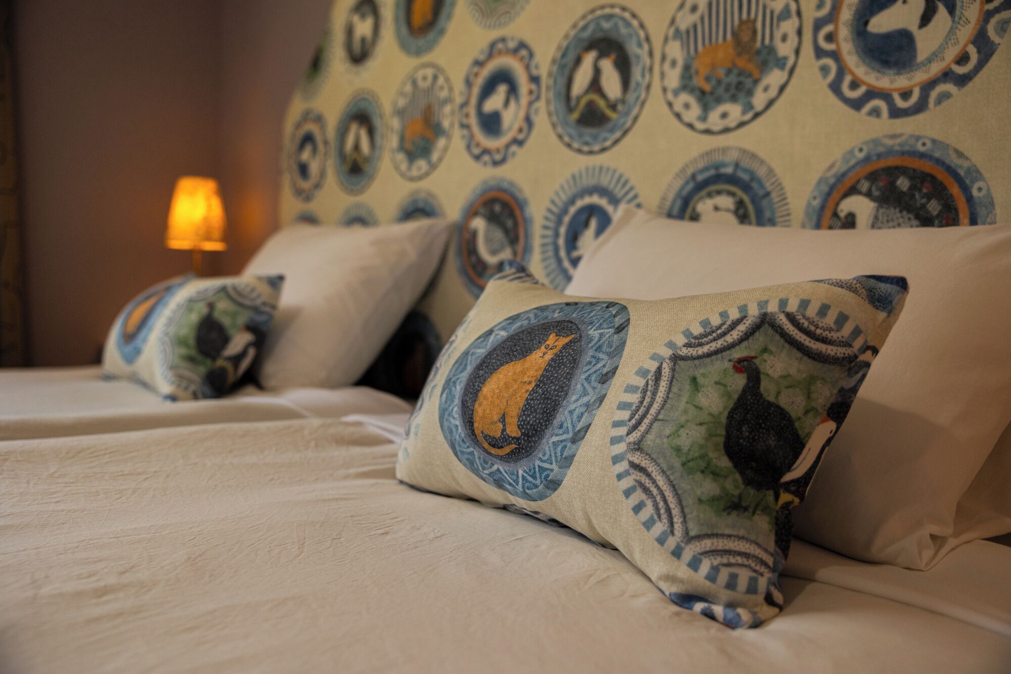 Una cama con almohadas estampadas y cabecera con diseños circulares.