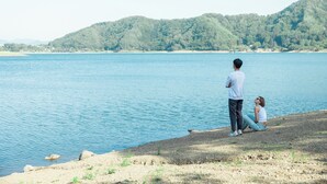 A couple by a lake with a forested hill in the background. - Auberge The Kawaguchiko Villa (Fujikawaguchiko)
