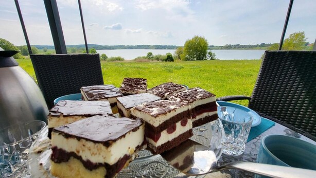 Ein Tisch mit Desserts und Blick auf einen See.