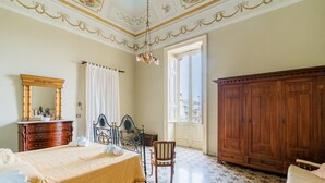 Ein Schlafzimmer mit Bett, Kommode, Stuhl und Kleiderschrank.