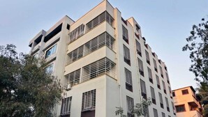 Ein mehrstöckiges Gebäude mit modernem architektonischen Design, mit Balkonen und großen Fenstern.