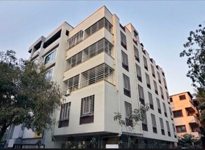 Ein mehrstöckiges Gebäude mit modernem architektonischen Design, mit Balkonen und großen Fenstern.