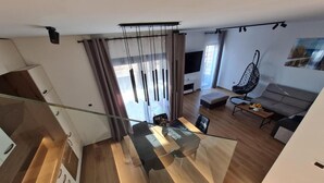 A modern living space with a staircase, a sofa, a coffee table, and a hanging chair. - House With Private Jacuzzi Near Umag (Umag)