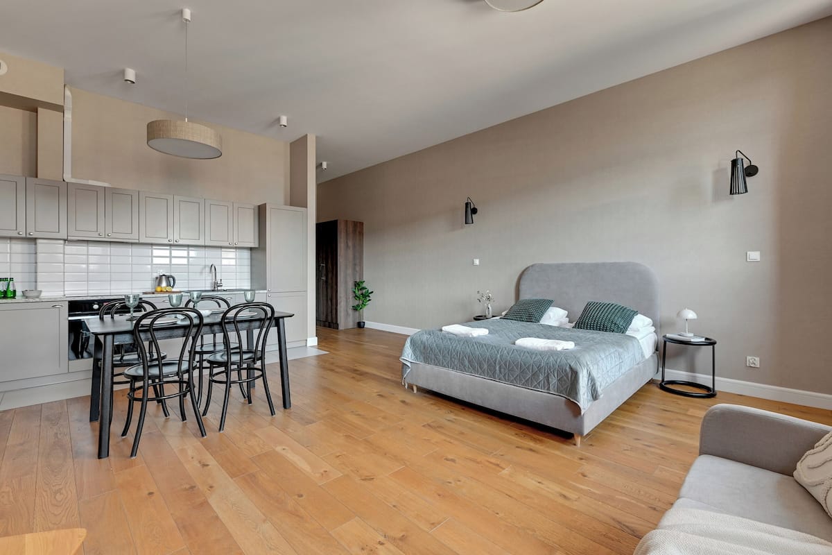 Eine moderne Wohnung mit Küche, Essbereich und einem großen Bett.