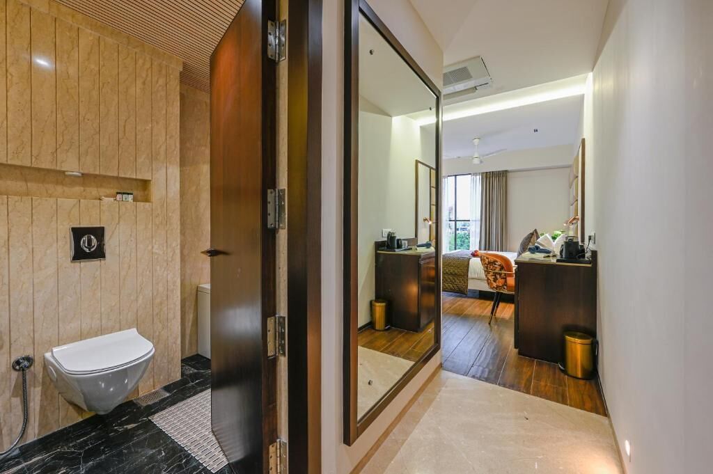 A modern bathroom with a marble vanity, a toilet, and a large mirror.