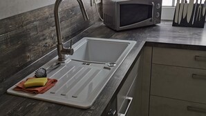A kitchen with a sink, a microwave, and a knife block. - Deluxe vacation apartment / near Willingen (Korbach)