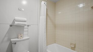 A bathroom with a toilet, a shower curtain, and a bathtub. - Premium Room, 1 Queen Bed, Lake View (Polson)
