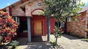 A house with a wooden door, a brick exterior, and a tiled driveway. - Upland Serviced Apartments (Lusaka)