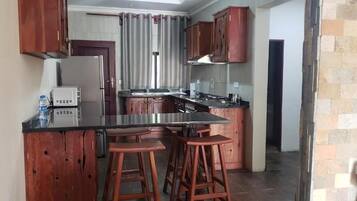 Apartamento Deluxe, 2 habitaciones, patio | Cocina privada | Frigorífico grande, microondas, horno y placa de cocina