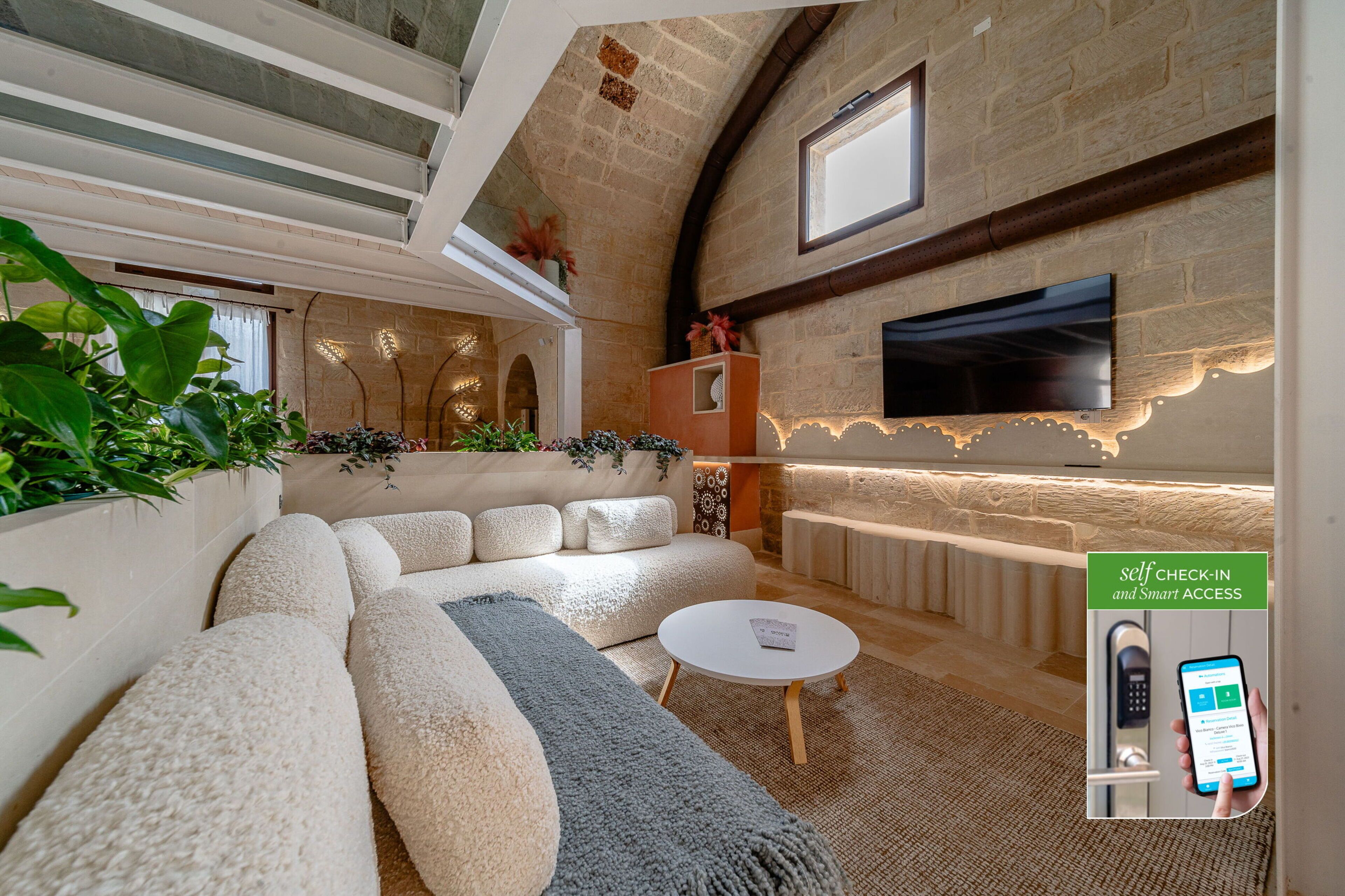 A modern interior with a sofa, coffee table, and a flat-screen TV mounted on a brick wall.
