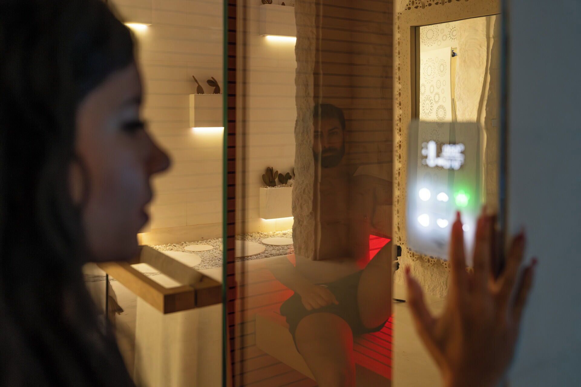 Iemand bedient een digitale interface, mogelijk roomservice of een bedieningspaneel, in een modern interieur met minimalistische decoratie en een zichtbaar bed.