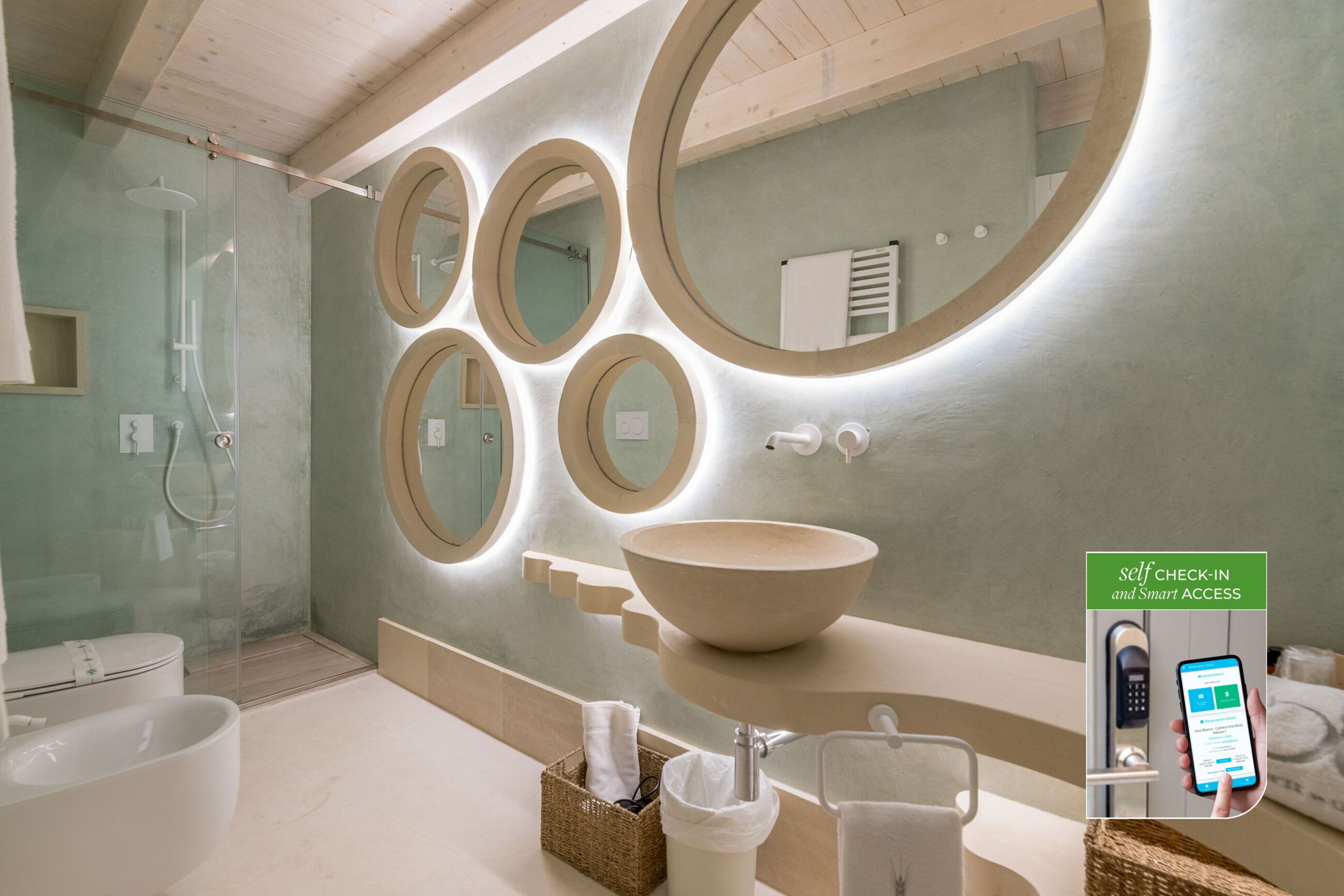 A modern bathroom with a large oval sink, multiple mirrors, and a self-check-in system.