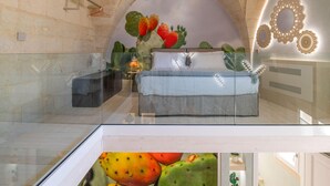 A bedroom with a glass ceiling, a bed with white bedding, and cactus decorations. - Corte Dei Granai Meeting&SPA Raro Rooms (Maglie)
