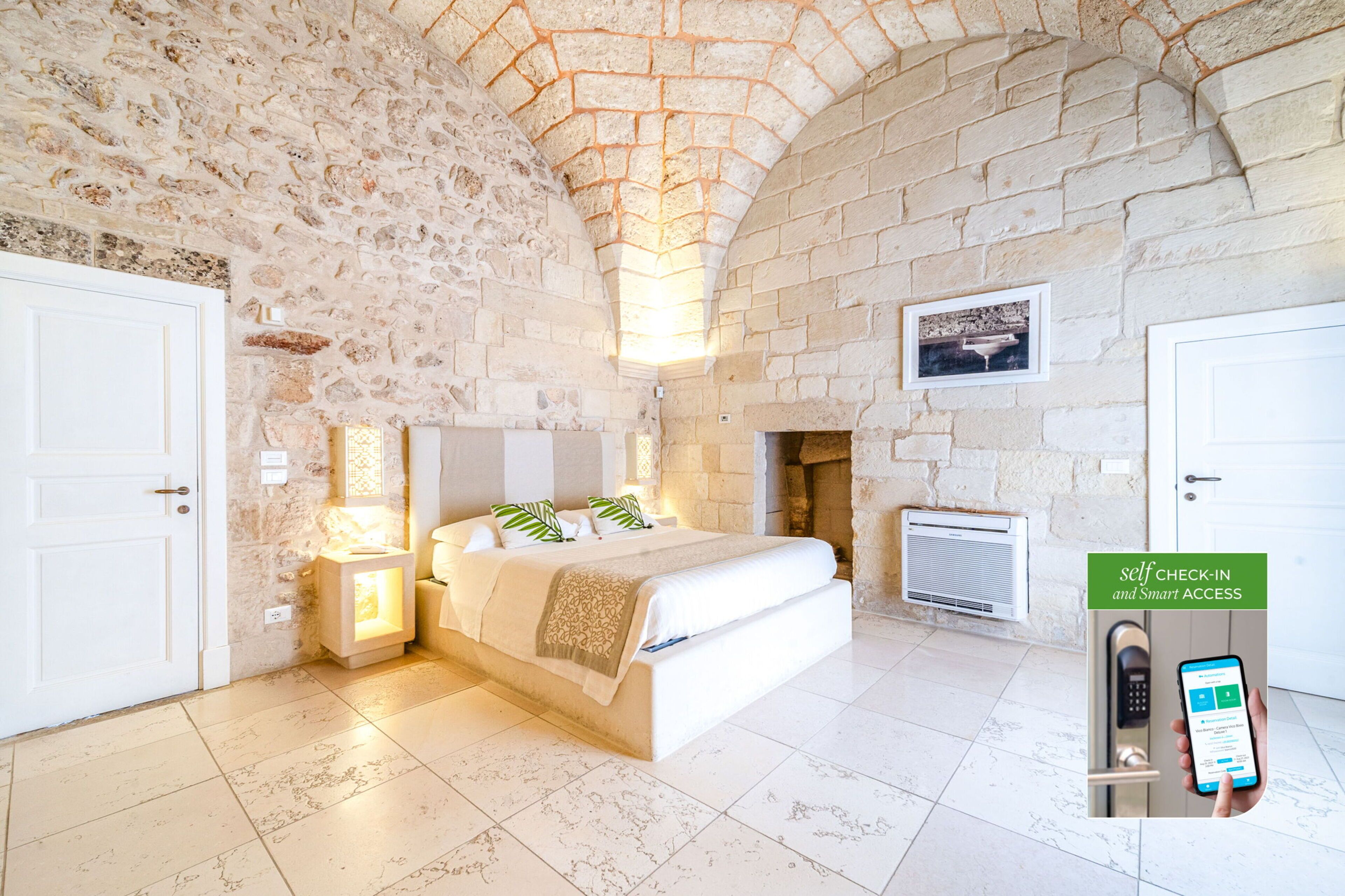 Un dormitorio con pared de piedra, una cama, una mesita de noche, una lámpara de pared y una chimenea.