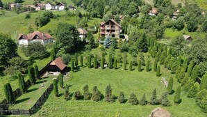 Une vue aérienne d’une zone rurale avec des maisons, un grand champ et des haies soigneusement taillées.