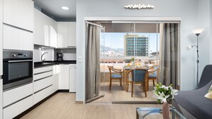 Una cocina moderna con comedor y balcón con vista a la ciudad.