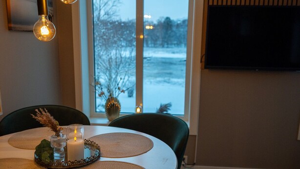 A dining area with a round table, chairs, and a candle centerpiece. - Cosy and charming  2-bedroom apartment in delightful Fauske for 1-6 persons (Fauske)