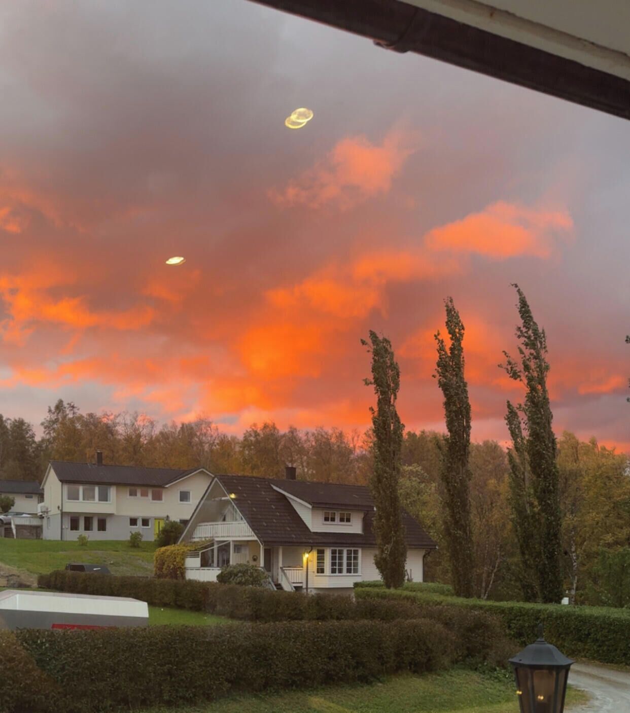 Ein Wohngebiet mit Häusern, einer Straße und einem Laternenpfahl.
