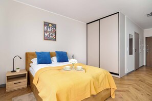 Ein ordentlich eingerichtetes Schlafzimmer mit Bett, Nachttisch und einem Bild an der Wand.