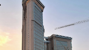Un immeuble de grande hauteur, doté d’un beffroi remarquable, d’une grande entrée en arc de cercle et situé au-dessus d’une rue animée.