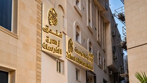 The exterior of the Zaharat Al-Fursan Hotel with a clear entrance, a staircase leading to the entrance, and a palm tree to the right. - Zahret Alforsan Hotel (Makkah)